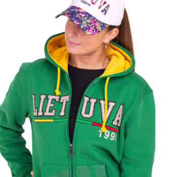 Moteris su žaliu bliuzonu „Lietuva 1990“ ir balta gėlėta kepure