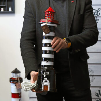 Klaipėdos švyturys šviestuvas laikomas rankose