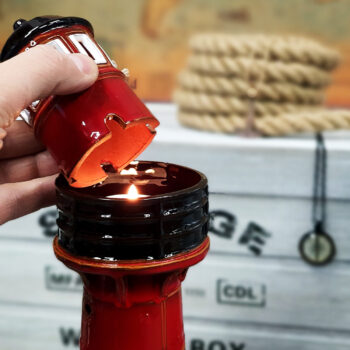 Pervalkos švyturys su žvake viduje skleidžiantis šviesą