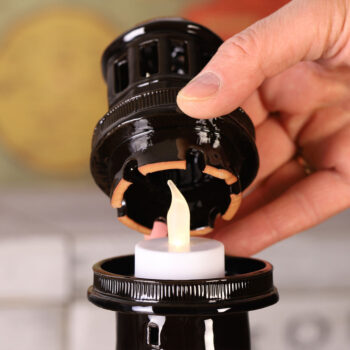 Žvakės įdėjimas į švyturio žvakidę